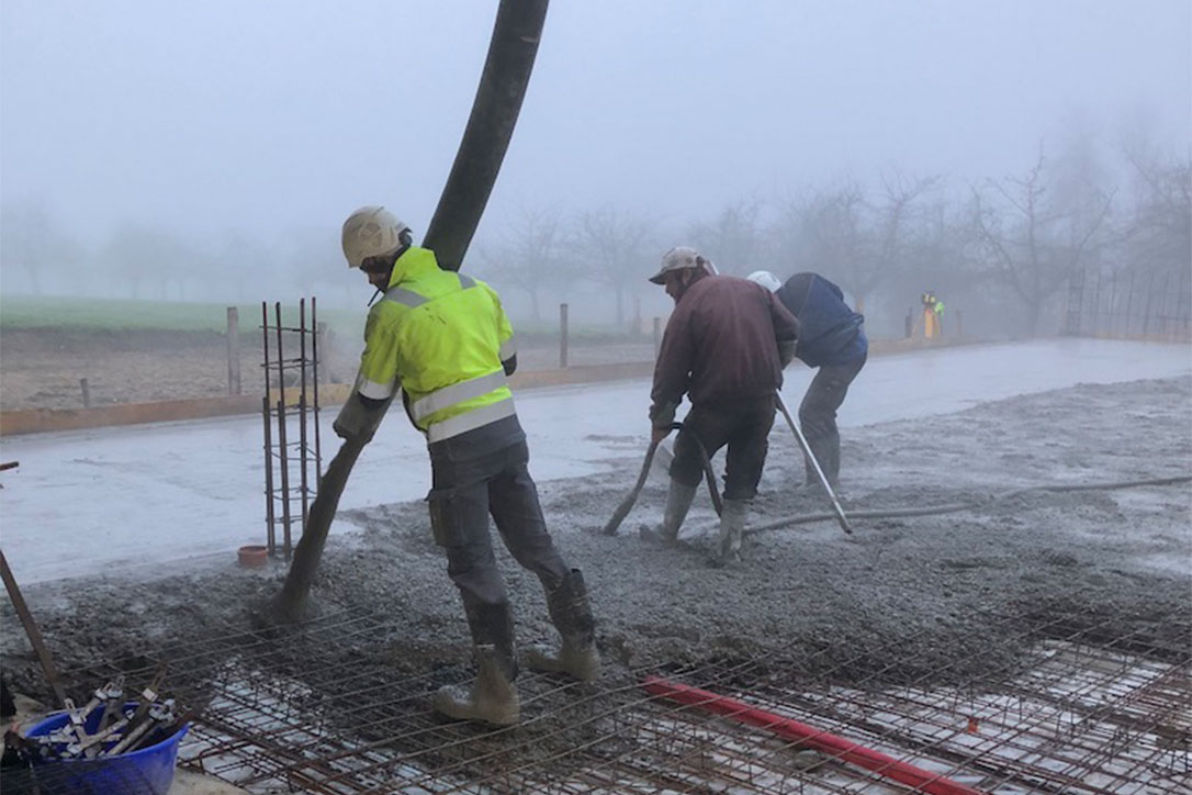 Fleissige Helfer betonieren den Hallenboden